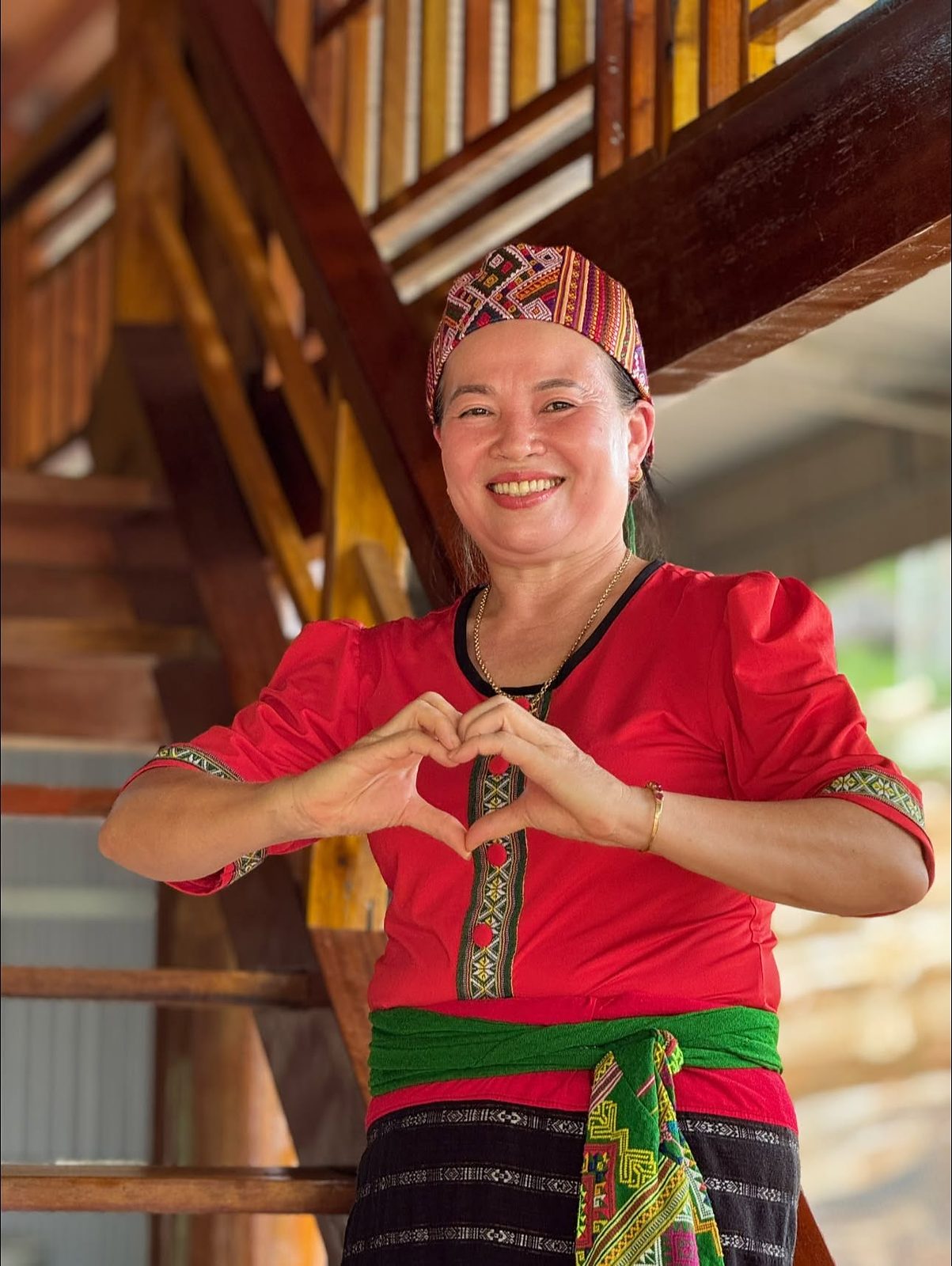 Phụ nữ Thái Quế Phong trong trang phục truyền thống bên nhà sàn